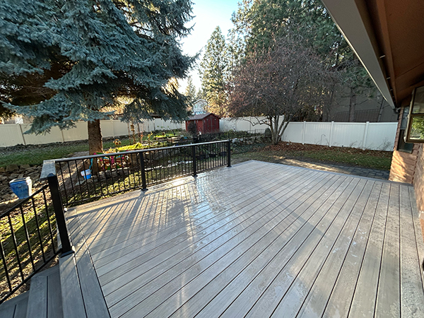 Showcasing a custom deck with a charming backyard, enhanced by soft sunlight for a relaxing outdoor atmosphere.