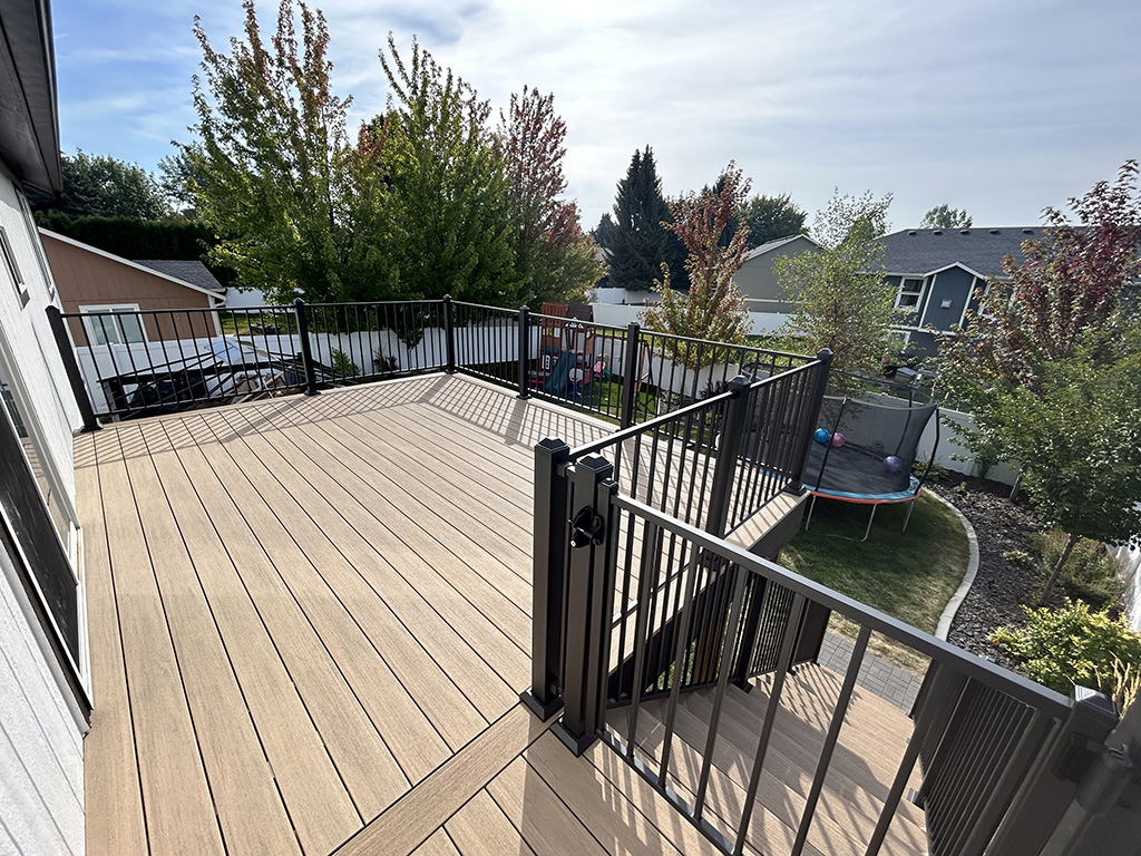 Stunning back deck built with teak-colored composite decking for a timeless look.