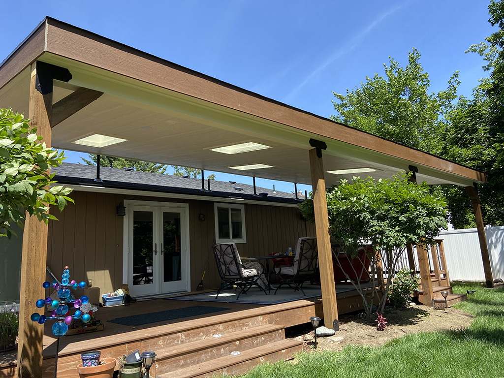 Lean-to roof cover over a deck with four staggered skylights.