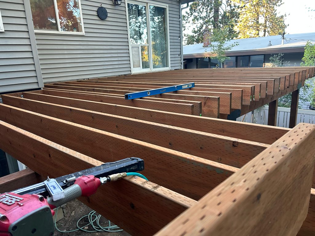 Close-up of a partially framed deck built with pressure-treated lumber.