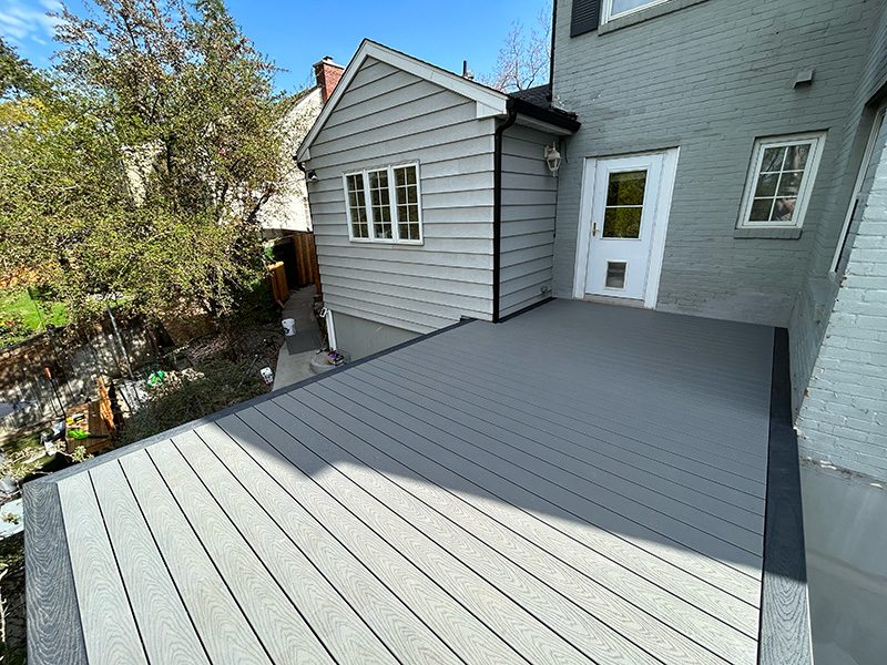 Deep deck extending off the back of a house, offering ample outdoor space.
