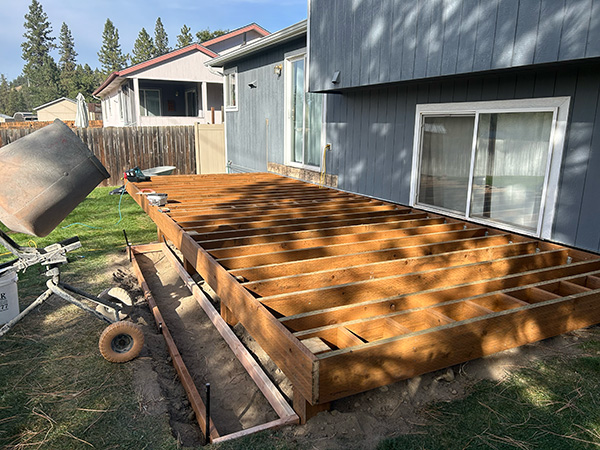 Ground-level deck framing with pressure-treated lumber sitting close to the ground.
