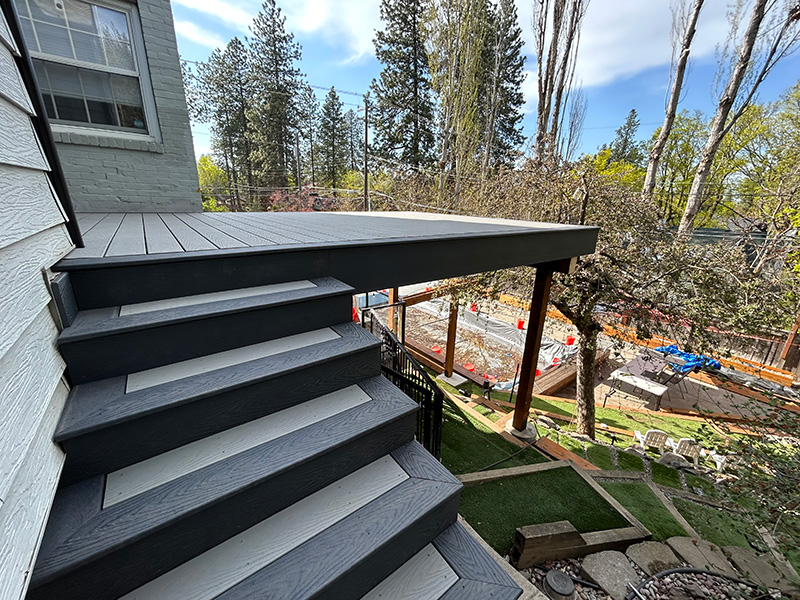 Deck standing above a backyard pool, providing a functional and stylish outdoor space.