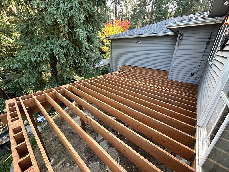 Two-story pressure-treated deck framing prepared for inspection as part of the permitting process.