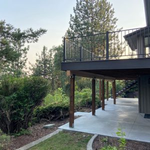 Built by Pacific Northwest Decks, this elevated composite deck includes a concrete patio below and black railing — a prime example of what the best deck builders in Spokane can deliver.