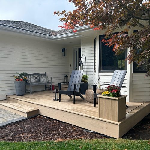 Front porch constructed with composite decking and a matching planter box, showcasing a low-maintenance and stylish design.