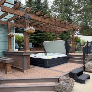 Built by Pacific Northwest Decks, this composite hot tub deck with a custom wood pergola and bar showcases the craftsmanship of the best deck builders in Spokane.