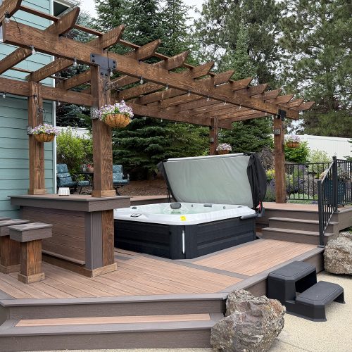Built by Pacific Northwest Decks, this composite hot tub deck with a custom wood pergola and bar showcases the craftsmanship of the best deck builders in Spokane.